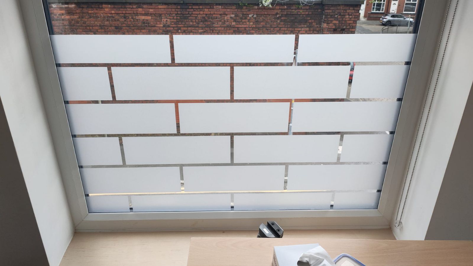 Frosted window vinyl with brick pattern applied to window for privacy