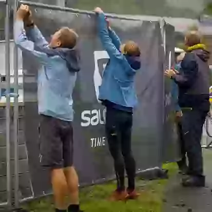 Event organisers hanging construction fence banner