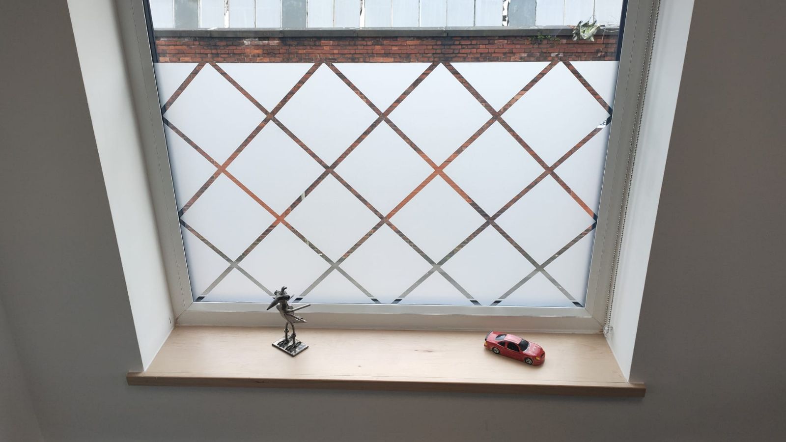 Frosted vinyl diamond pattern applied to window for privacy