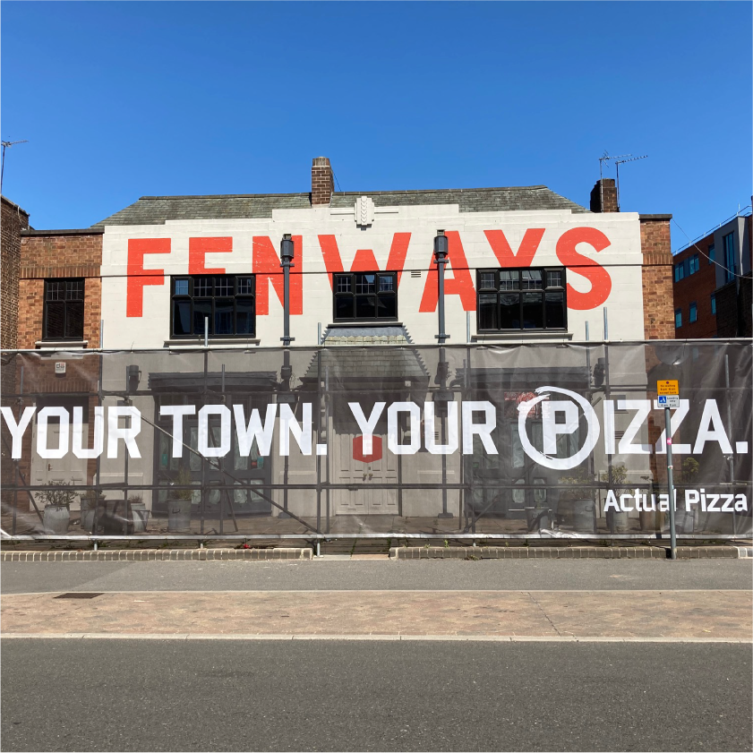 Mesh banner with hemmed edge & eyelets on construction fence